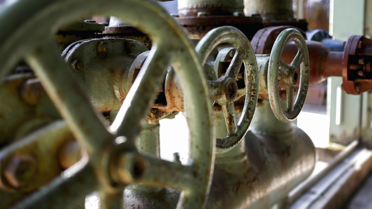 Close-up of industrial metal valve wheels and pipes