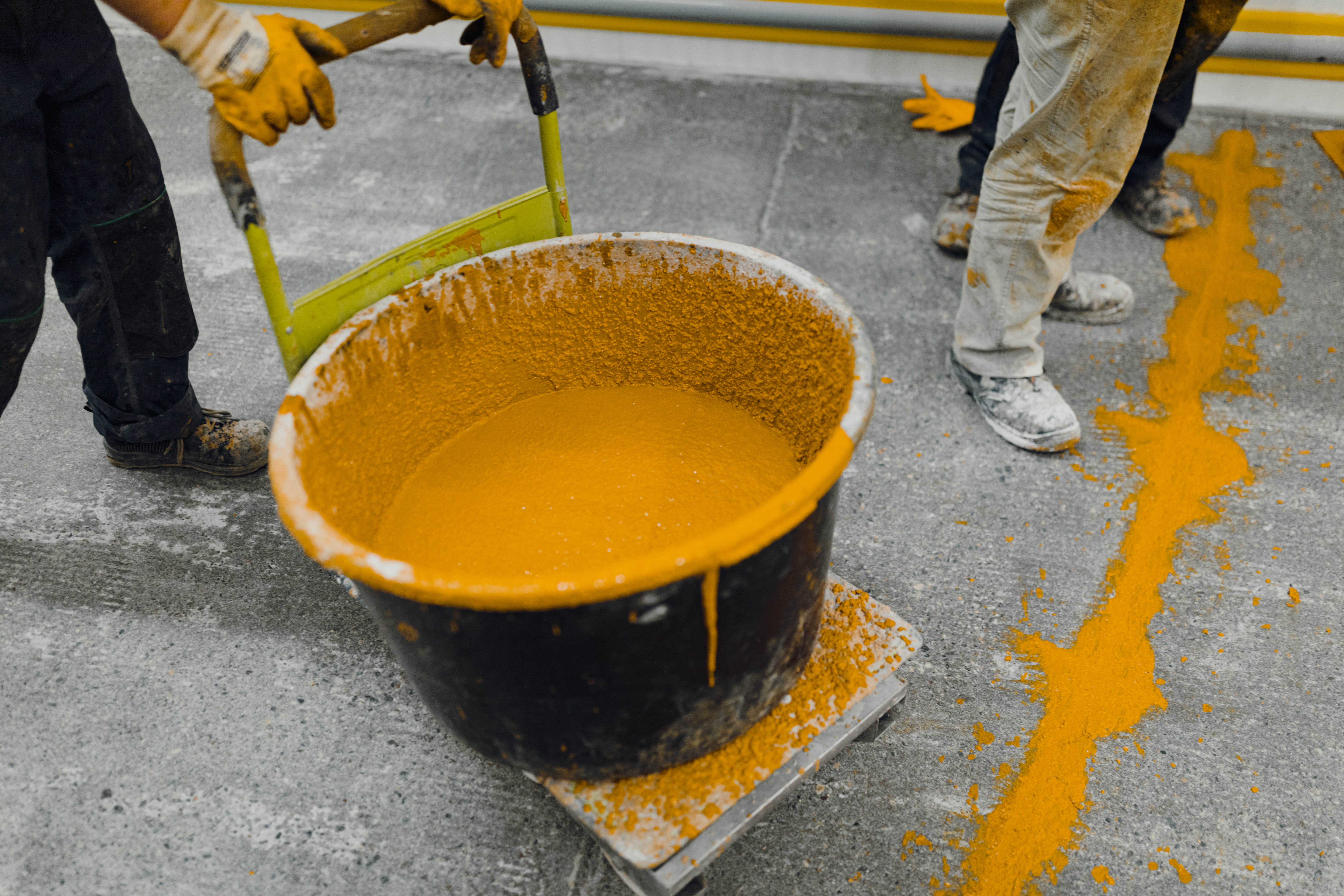 Large bucket of orange paint in workshop