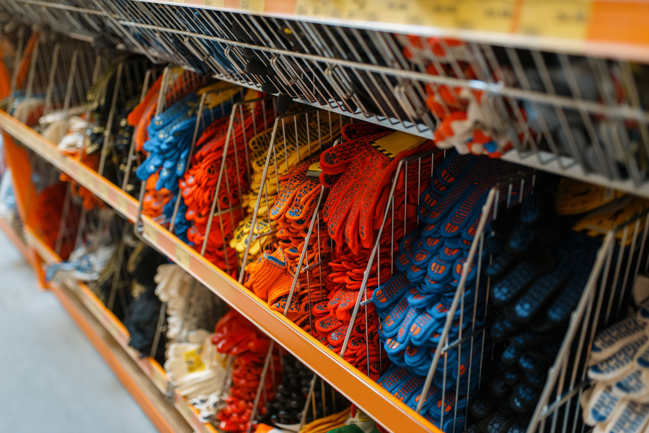 Assorted work gloves displayed on hardware store shelf