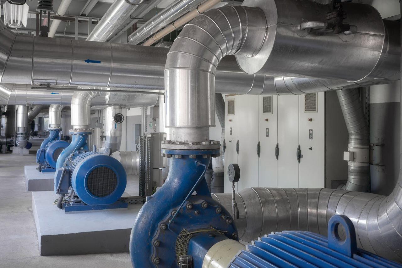 Industrial facility with large blue pumps and pipes