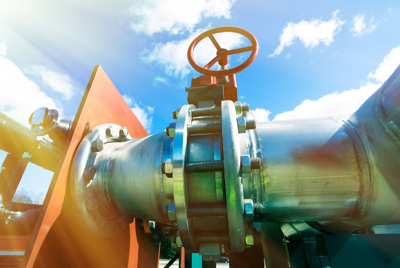 Industrial metal pipeline with large valve outdoors