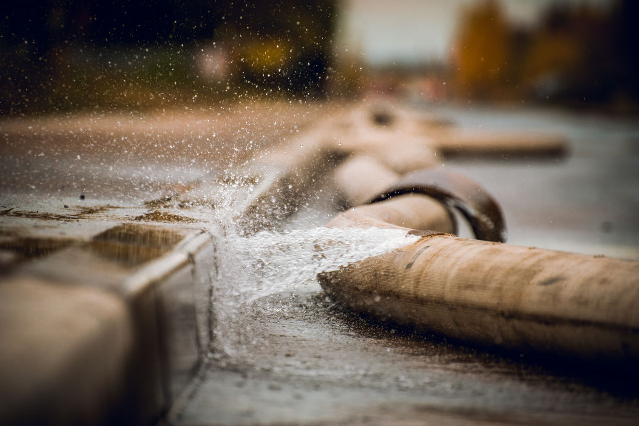 Water spraying from damaged fire hose on the street