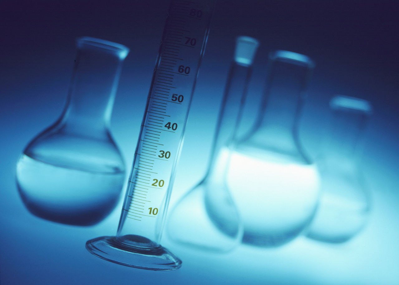 Laboratory glassware with graduated cylinder in focus