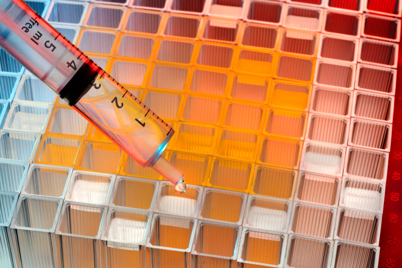 Syringe with liquid above laboratory sample grid