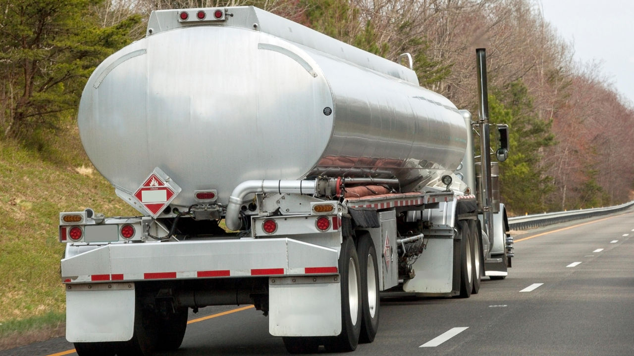 Large silver fuel tanker truck on highway road
