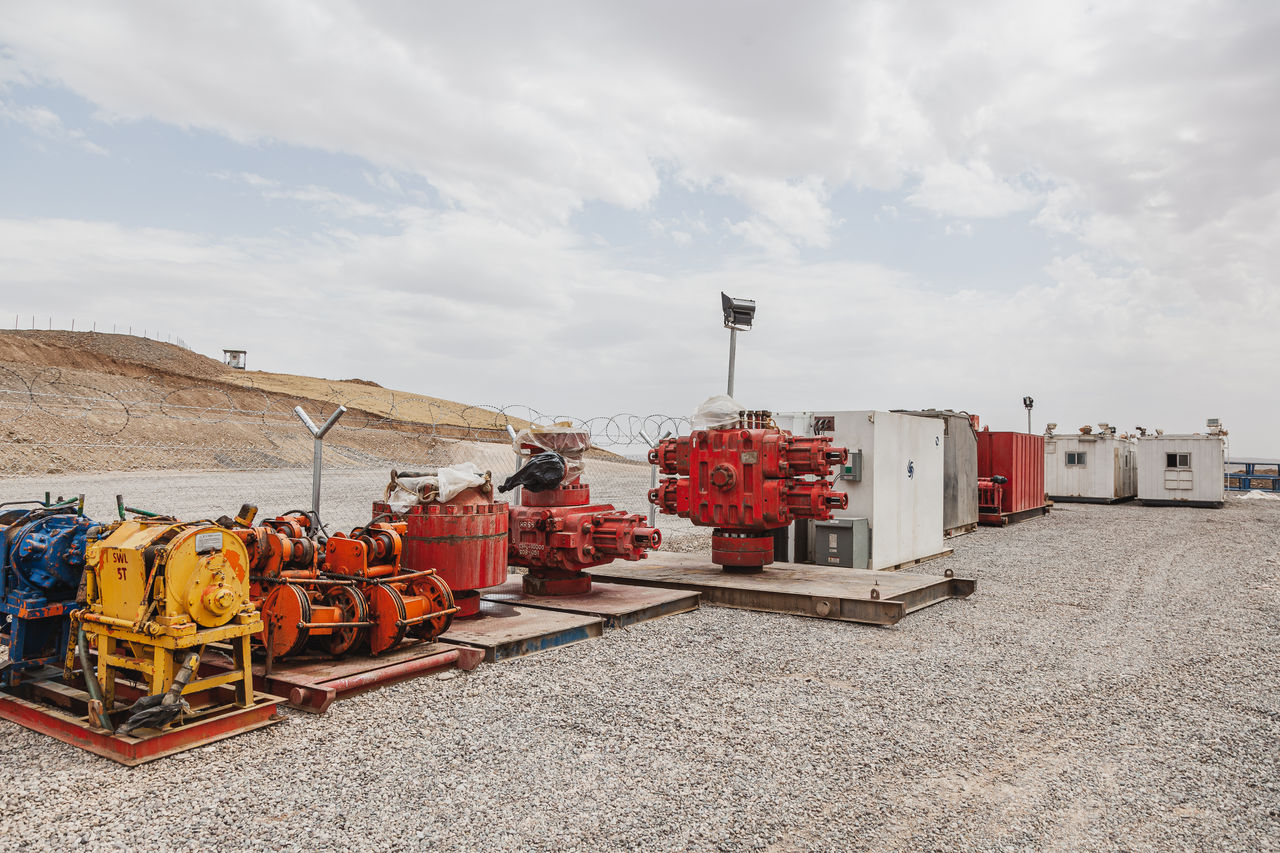 Industrial oilfield equipment on gravel worksite outdoors